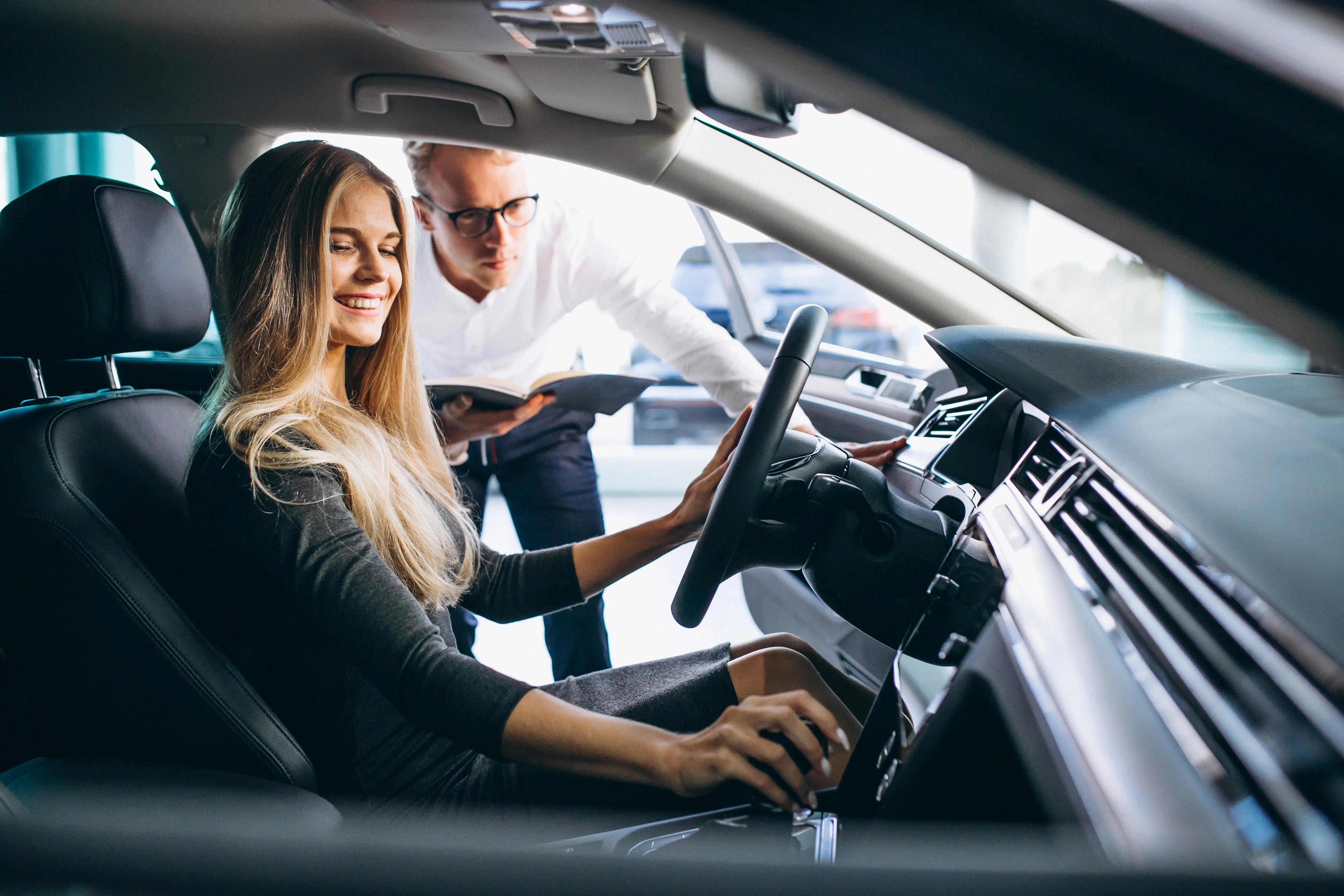 jonge-vrouw-die-een-auto-van-een-autotoonzaal-test